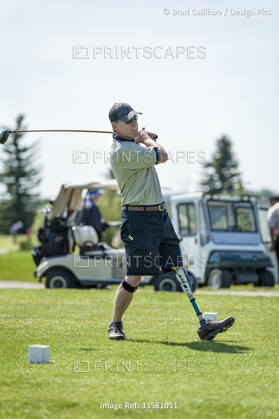 Amputee with leg prosthesis driving the ball on the golf course; Okotoks, ...