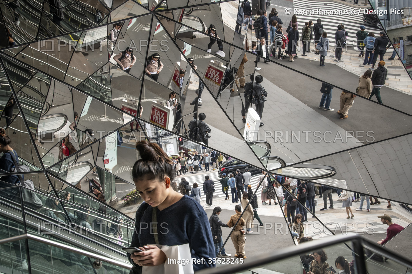 Woman on an escalator surrounded by multiiple mirrors in the Roppongi Hills ...