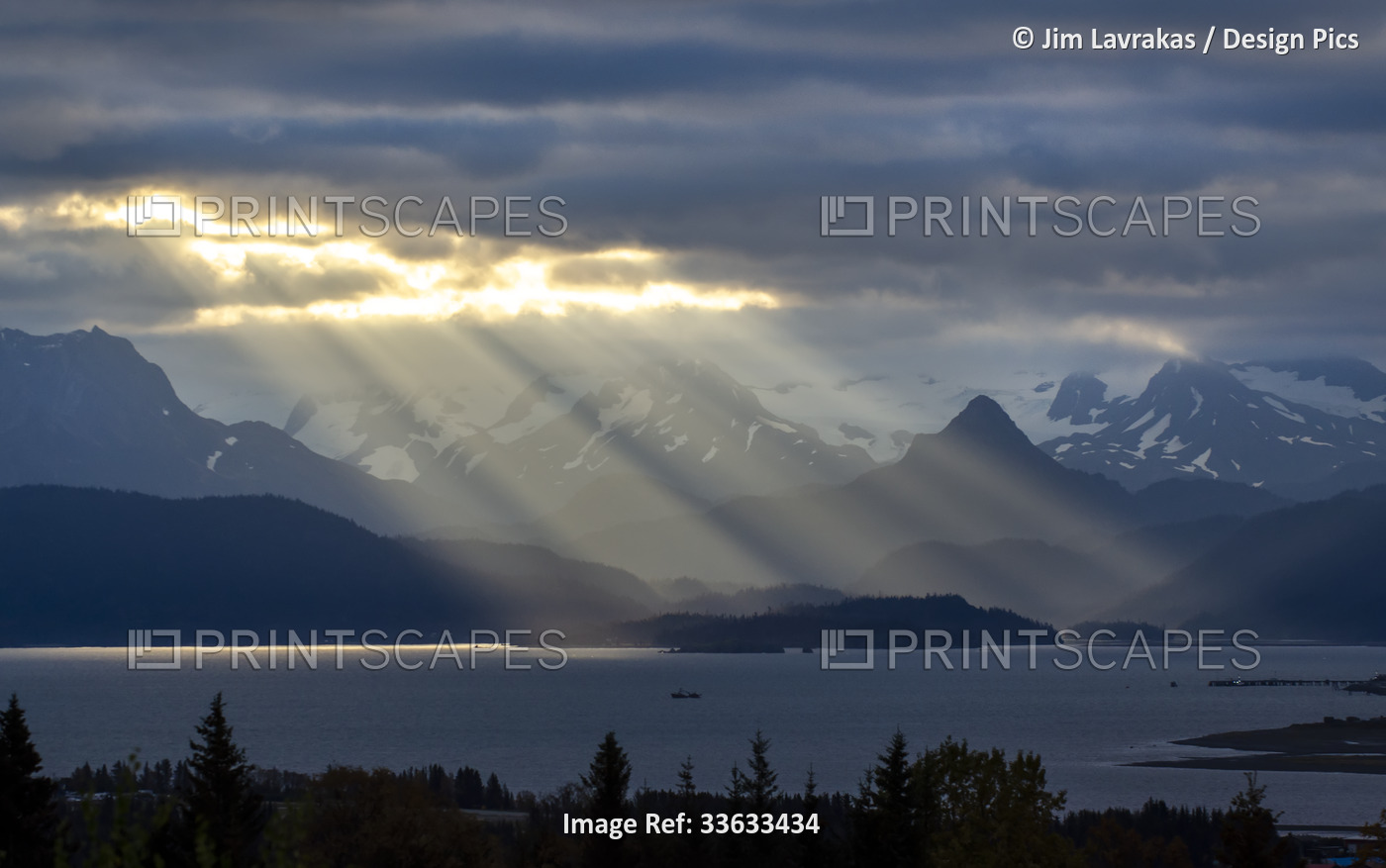 Sun rays light up the Poot Peak and the Kenai Mountains across Kachemak Bay ...