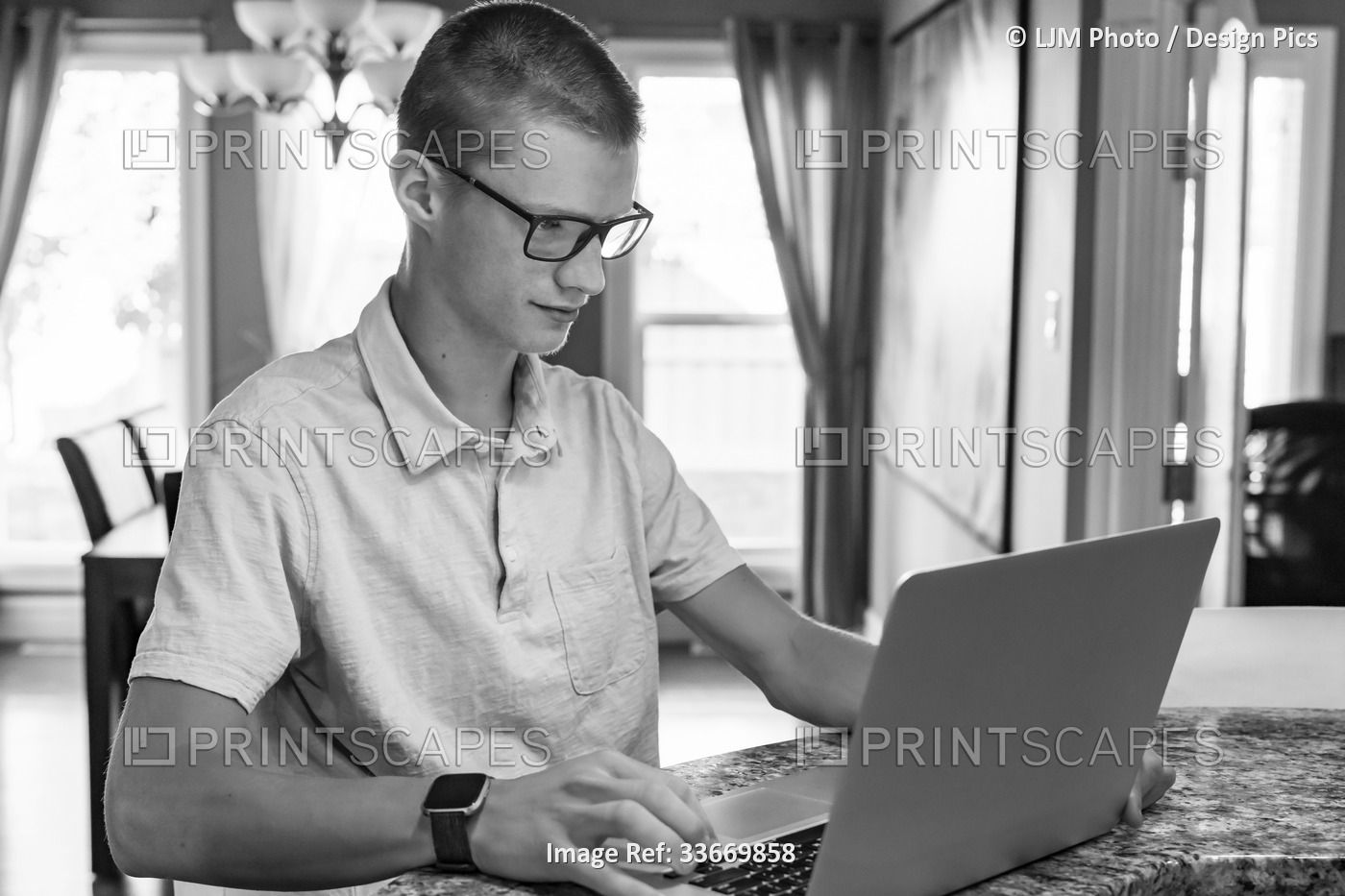 Young man uses a laptop computer at home; Edmonton, Alberta, Canada