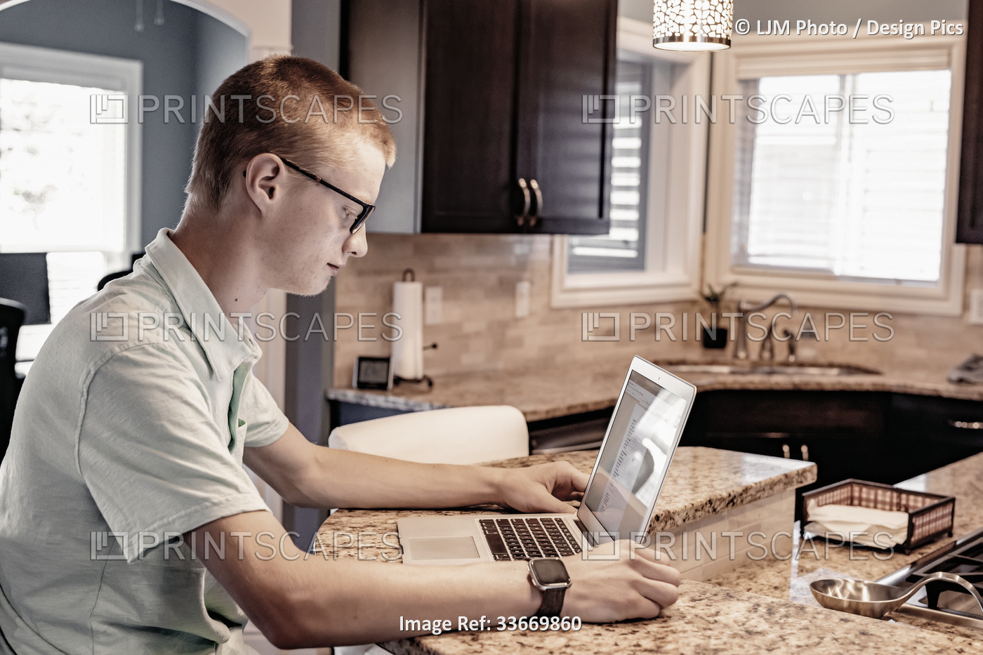 Young man uses a laptop computer at home; Edmonton, Alberta, Canada