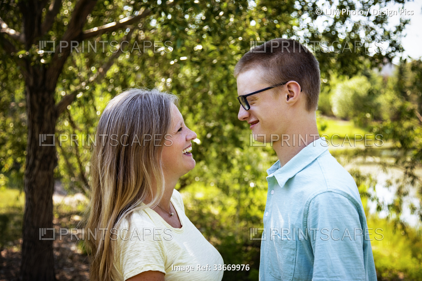Young men spending time together with his mother in a park; Edmonton, Alberta, ...