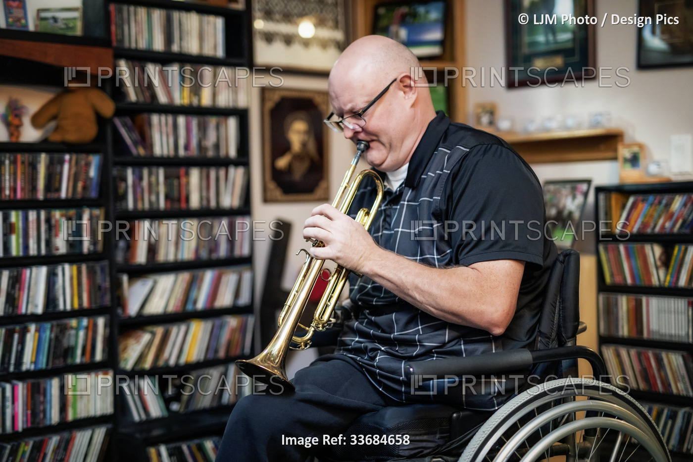 Man with double limb amputations playing the trumpet at home; St. Albert, ...