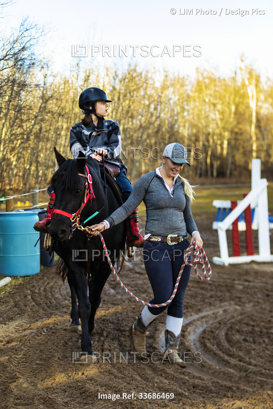A trainer working with a young girl with Cerebral Palsy during a Hippotherapy ...