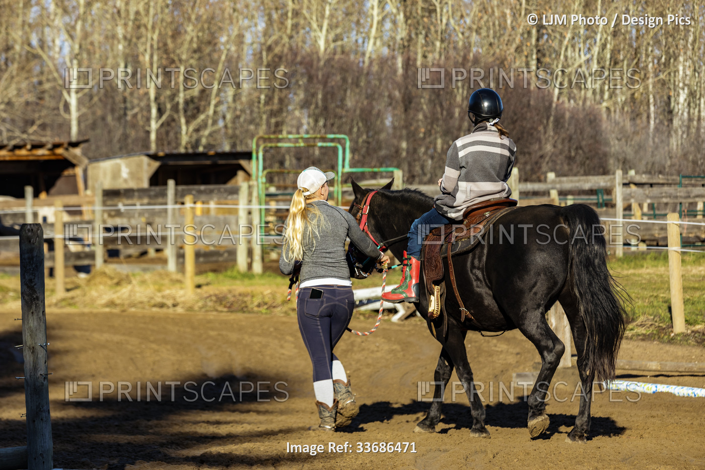 A trainer working with a young girl with Cerebral Palsy during a Hippotherapy ...
