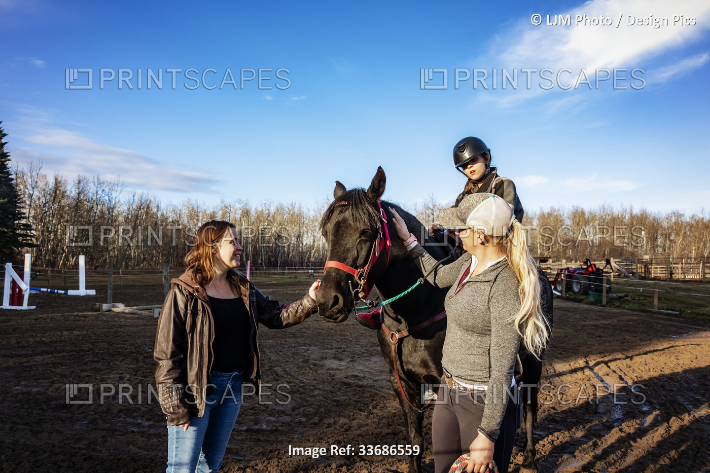 A young girl with Cerebral Palsy, her Mom and her trainer working with a horse ...