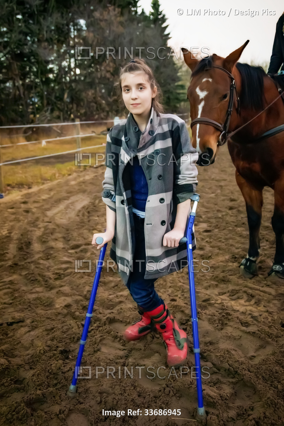 A young girl with Cerebral Palsy walking in a corral during a Hippotherapy ...