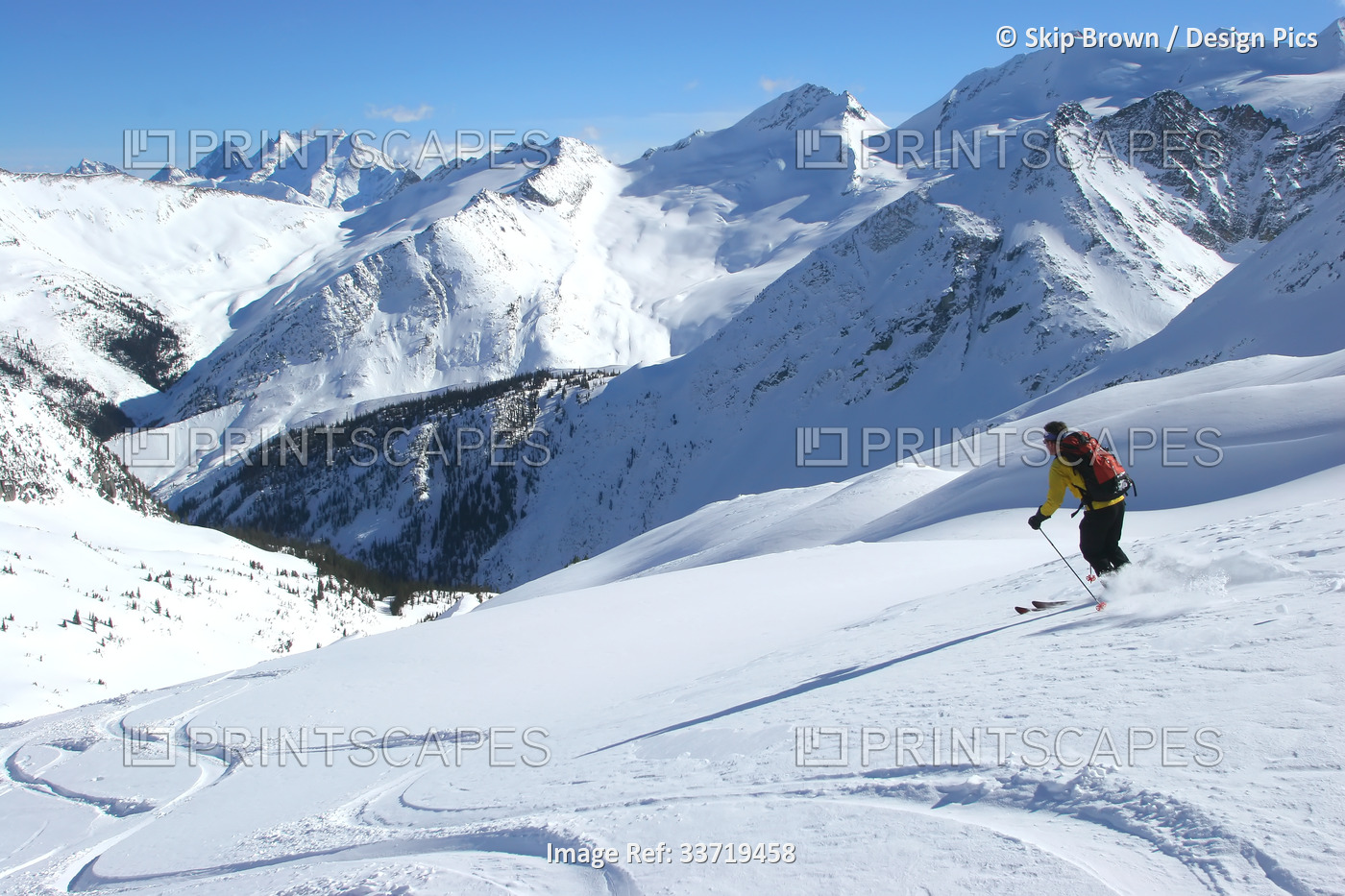 A lone backcountry skiier heads downhill in the Selkirk Mountains; British ...