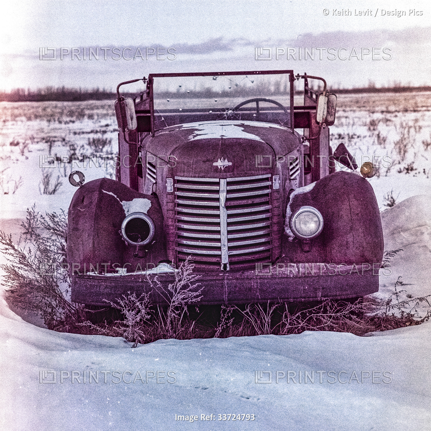 Vintage car abandoned in the countryside in a snowy field; Manitoba, Canada