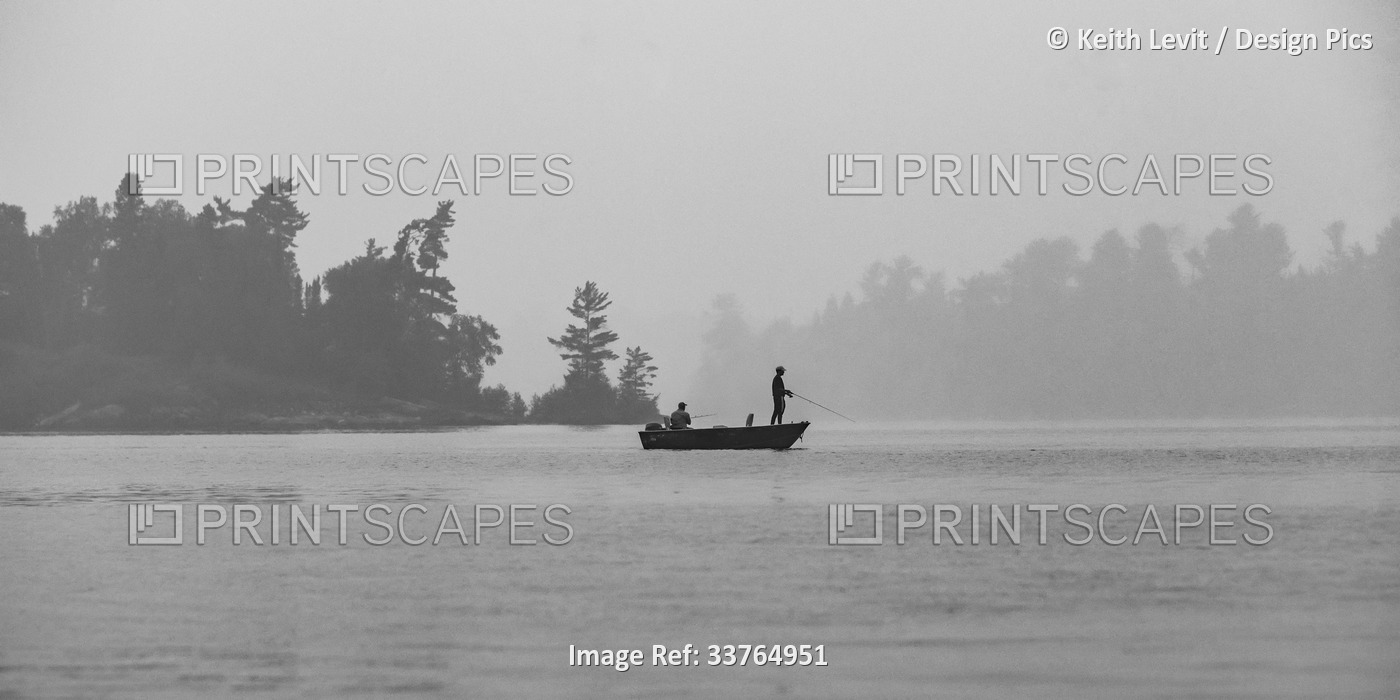 Boating and fishing on a lake with fog, Lake of the Woods, Ontario; Kenora, ...