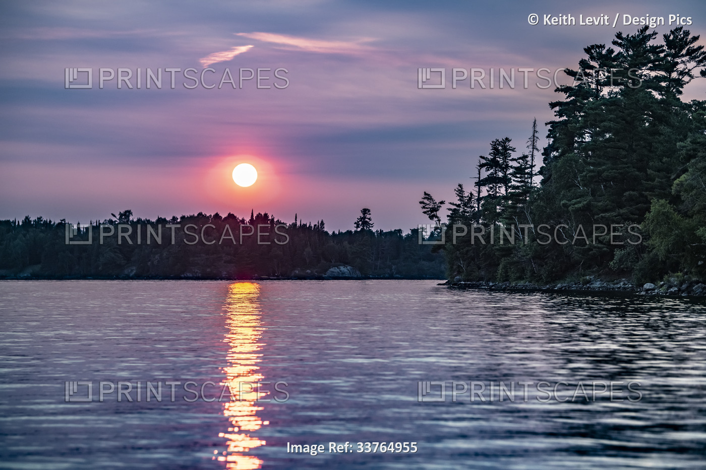 Vibrant sun glowing over tranquil lake and forest at sunset and sunbeam ...