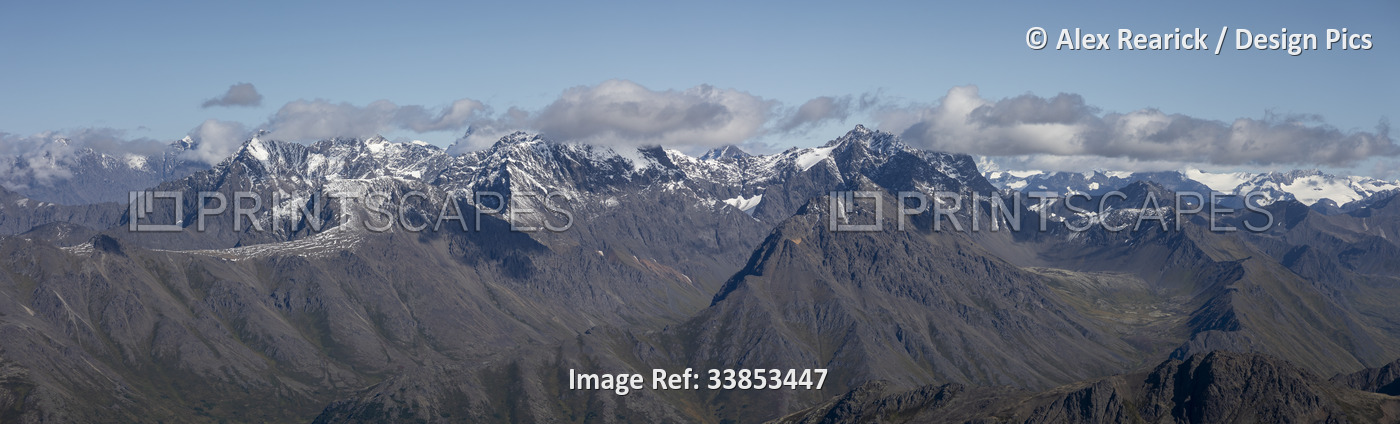 Scenic overview of the grey, snow-capped peaks of the Chugach Mountain Range ...