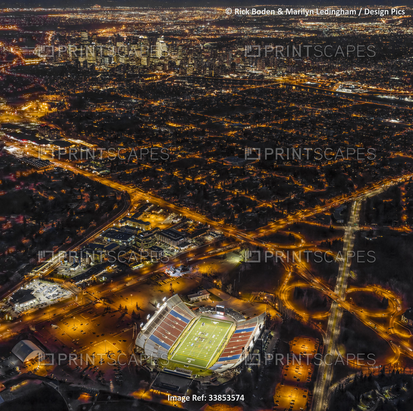 Aerial view of downtown Calgary, Alberta, Canada at night and the football ...