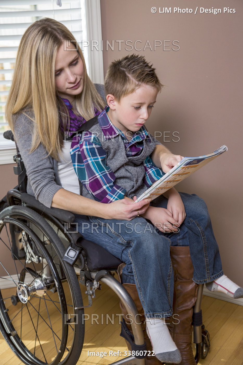 Young paraplegic mother reading a book to her son while sitting in her ...