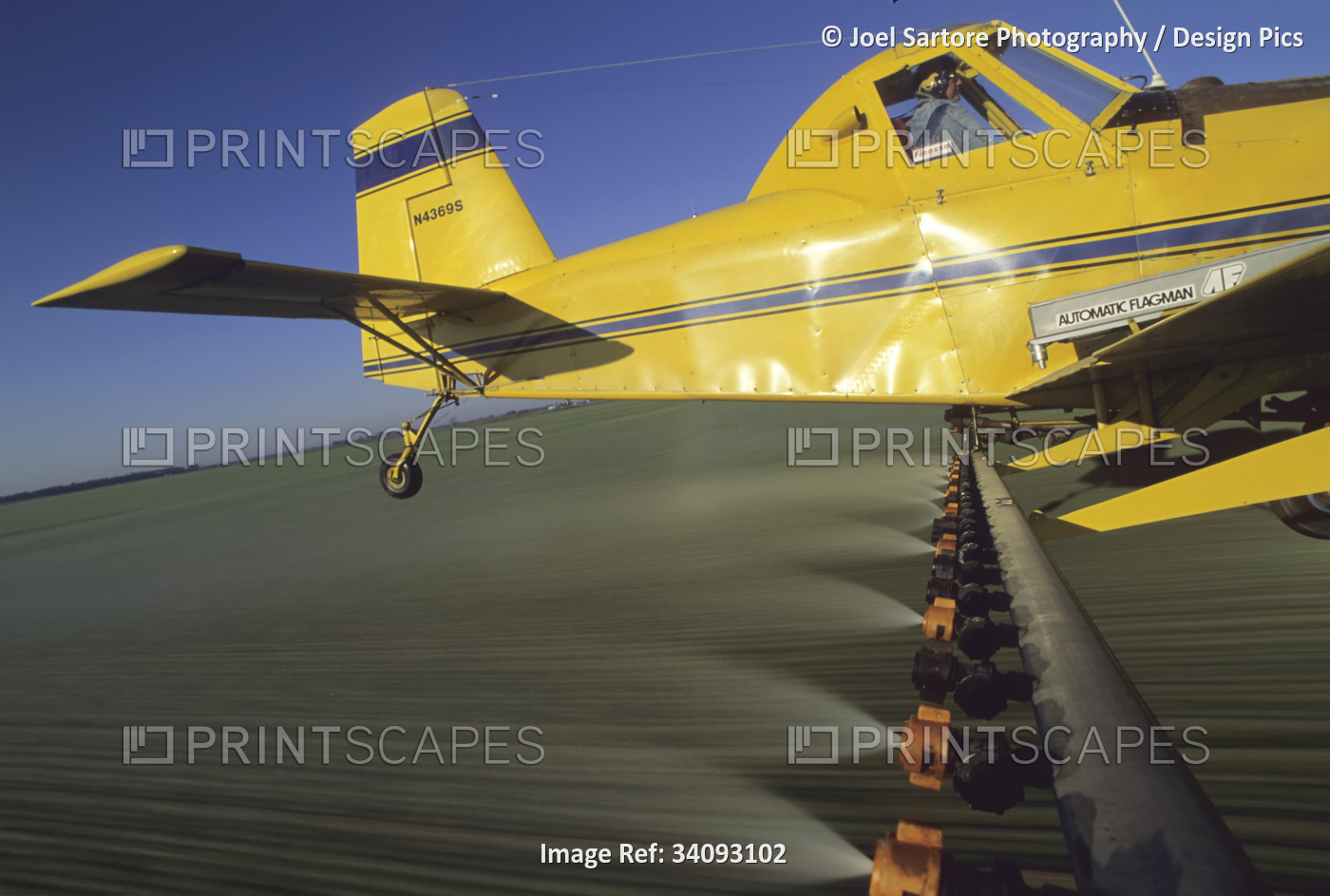 A crop duster sprays a winter wheat field with pesticides; Pond Creek, ...