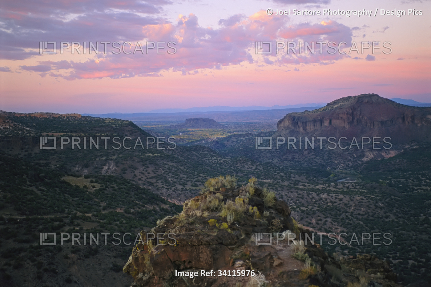 Gorges and rock formations on a vast desert landscape at sunset; New Mexico, ...