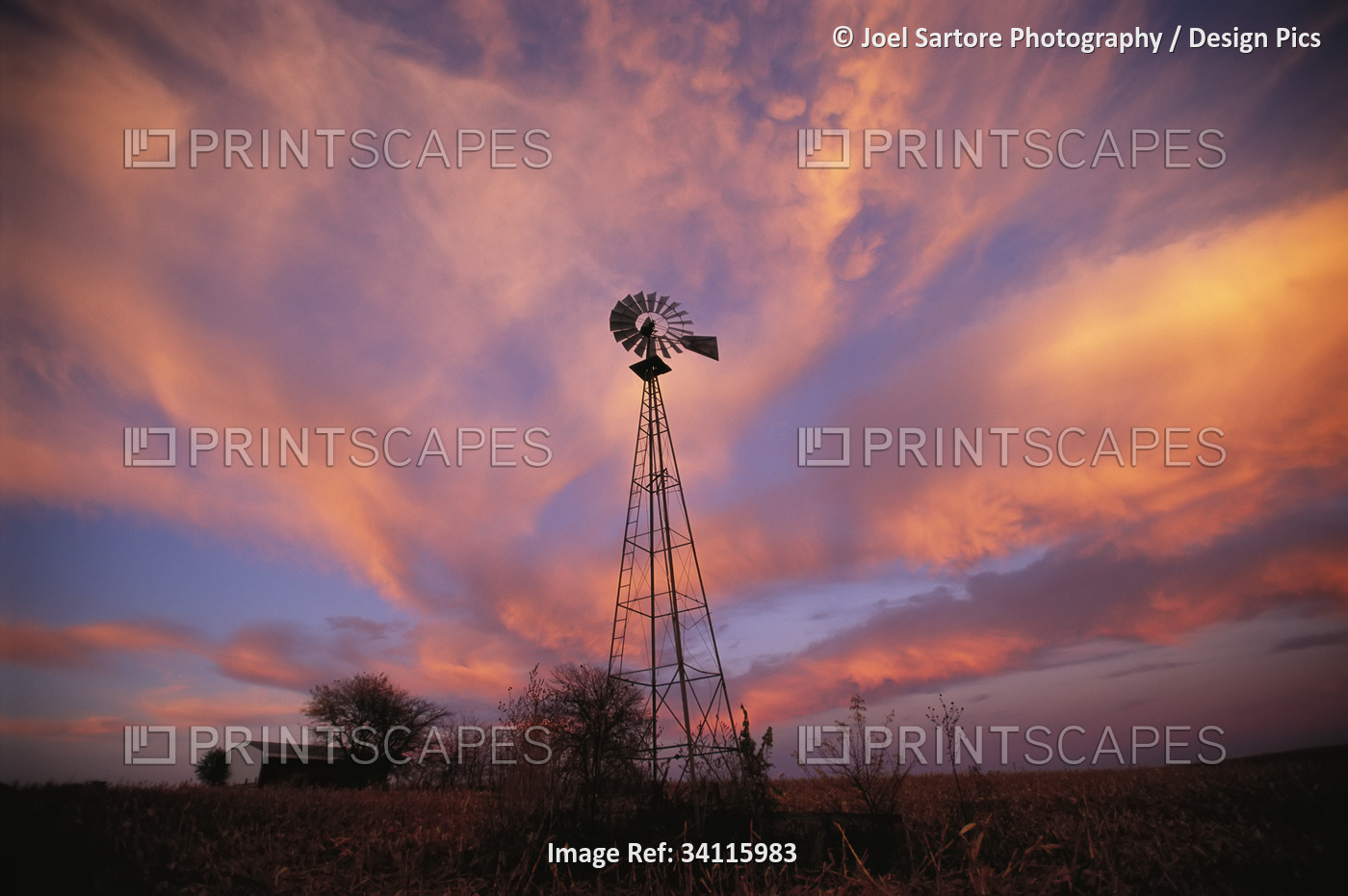 Silhouette of a tall wind vane in a glowing sunset sky; Dunbar, Nebraska, ...