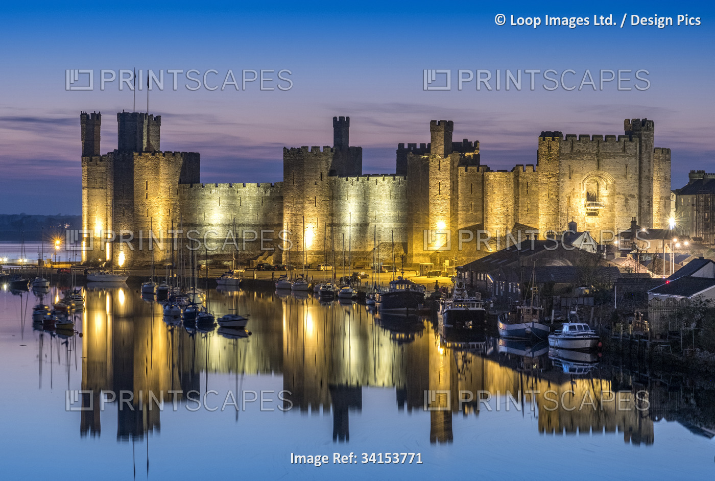 Caernarfon Castle and the River Seiont at night.