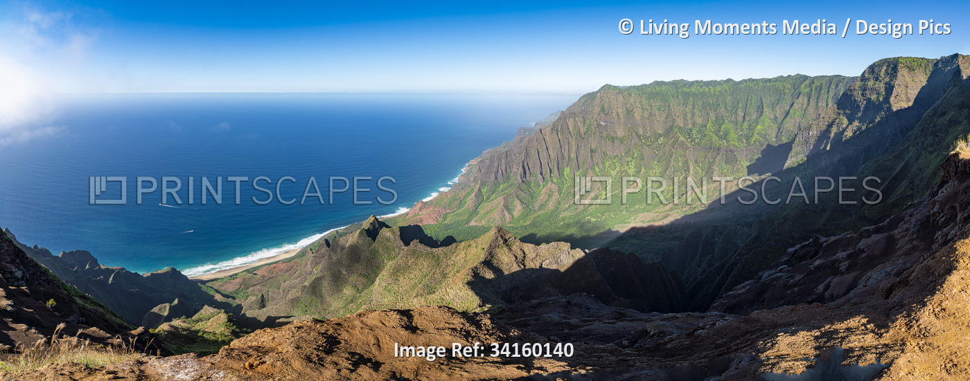 Panoramic image of a sunlit rugged landscape and ocean along the Na Pali Coast ...