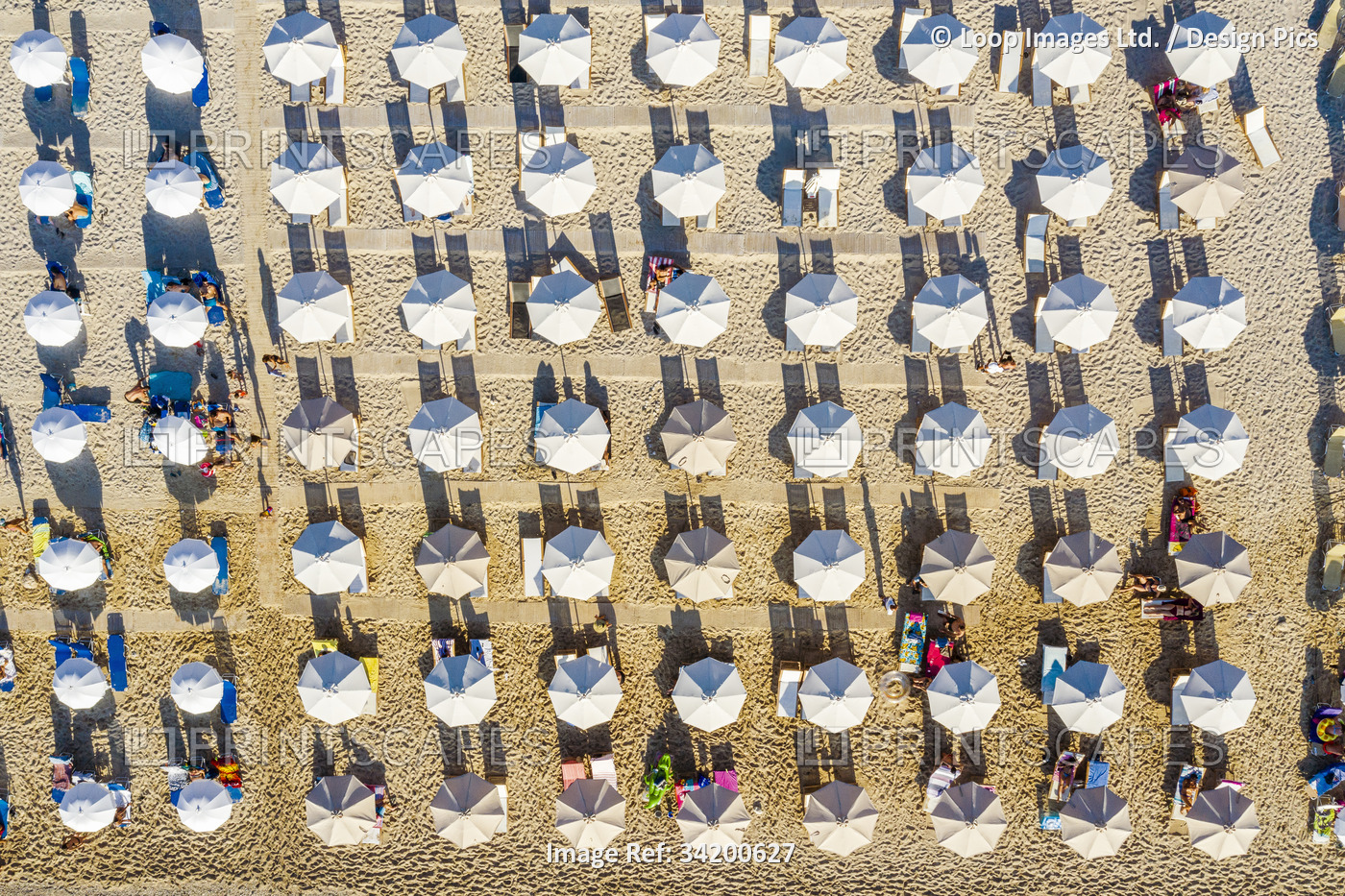 Aerial view of beach umbrellas pretty well aligned in Lefkada in Greece.