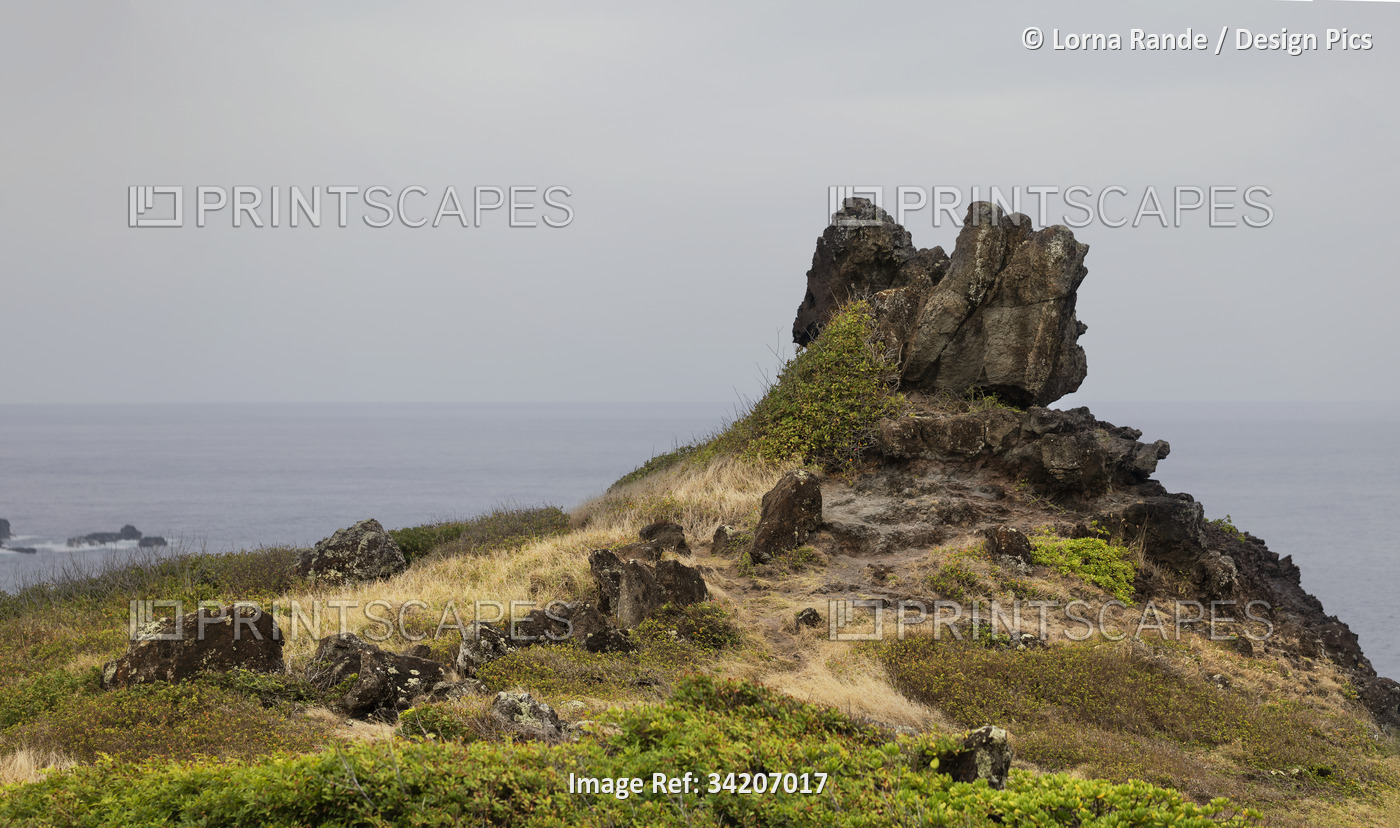 Volcanic rock formations along the cliffs of the Pacific Ocean on a cloudy day ...