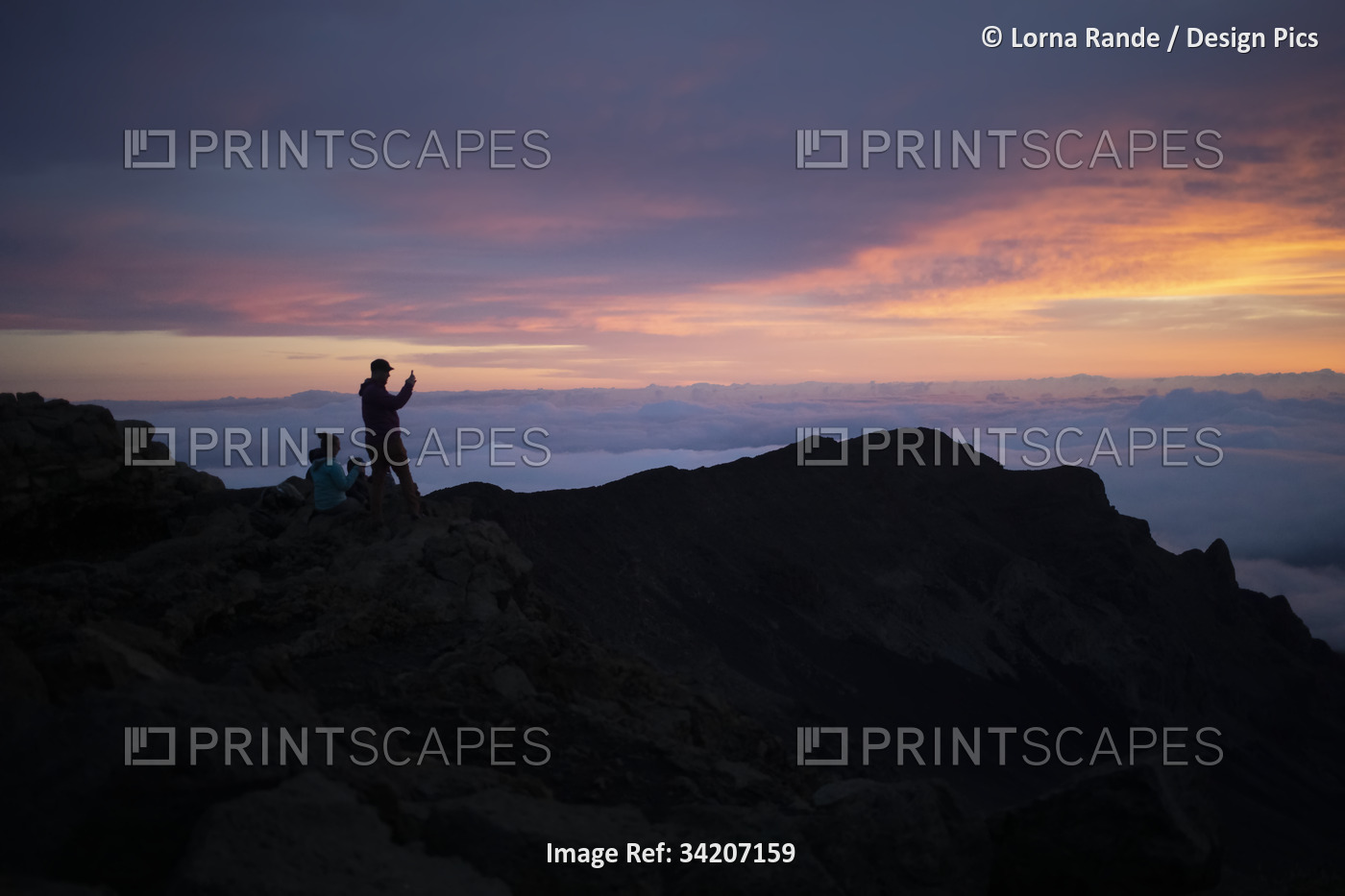 Family on a mountain top above the clouds at Haleakala watching the sunrise ...