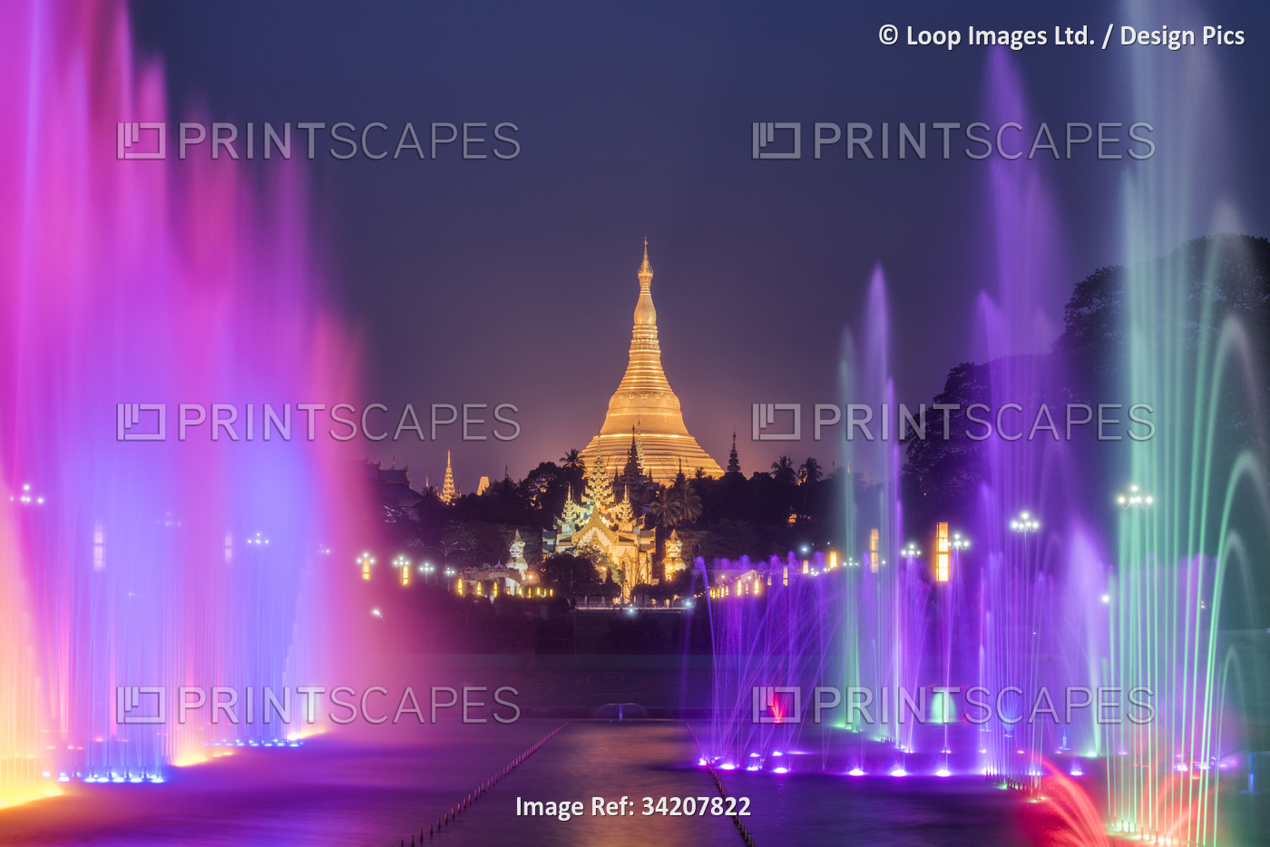 Public Square with lit water fountains and Shwedagon Pagoda at night in Yangon.