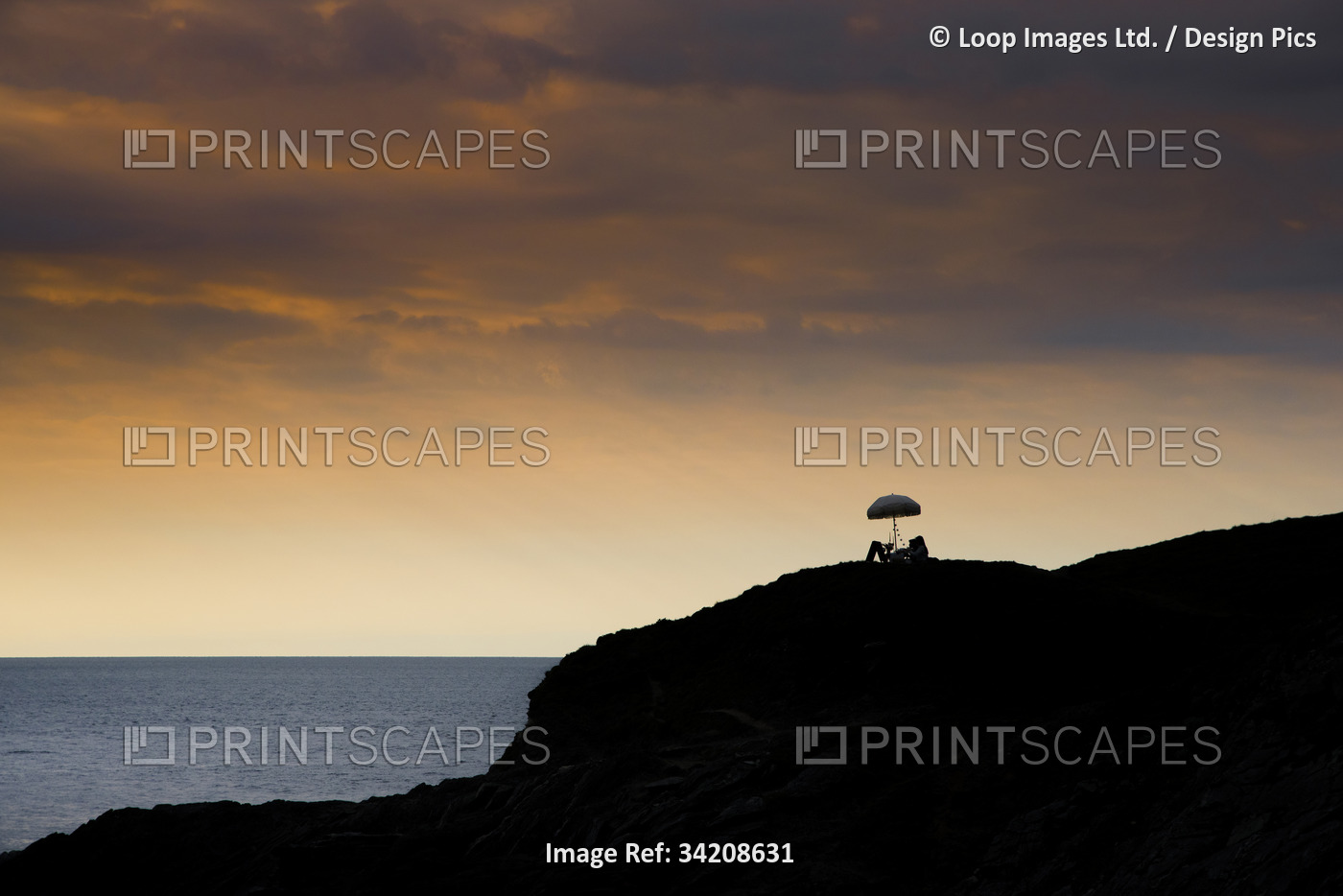Late evening light over a picnic table and an umbrella on Towan Head in Newquay ...