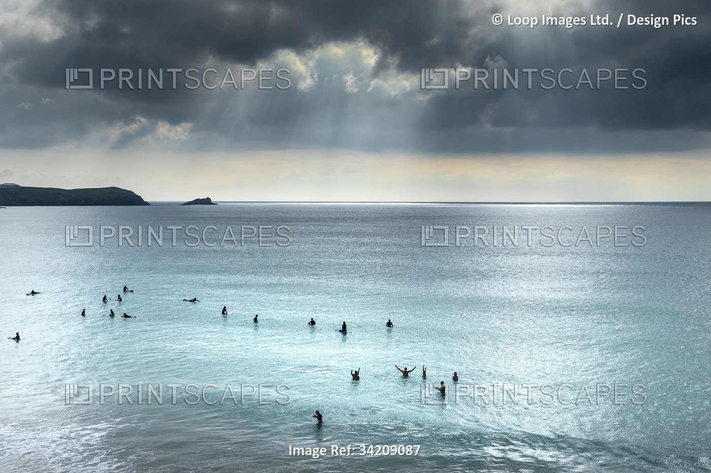 Surfers waiting for a wave on a calm sea at Fistral in Newquay in Cornwall.