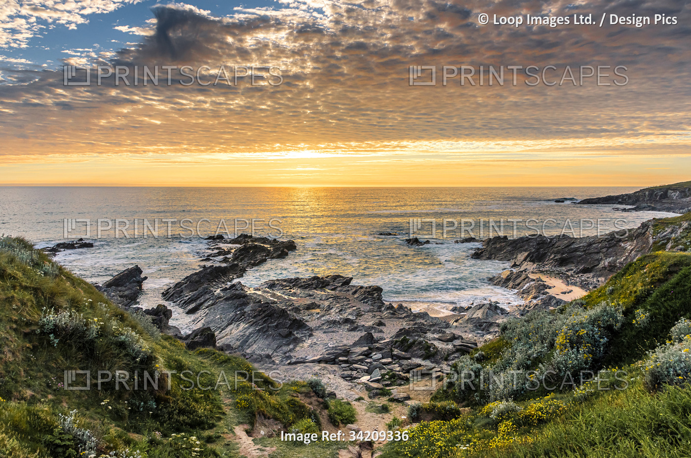 A beautiful colourful sunset over Little Fistral on the coast of Newquay in ...