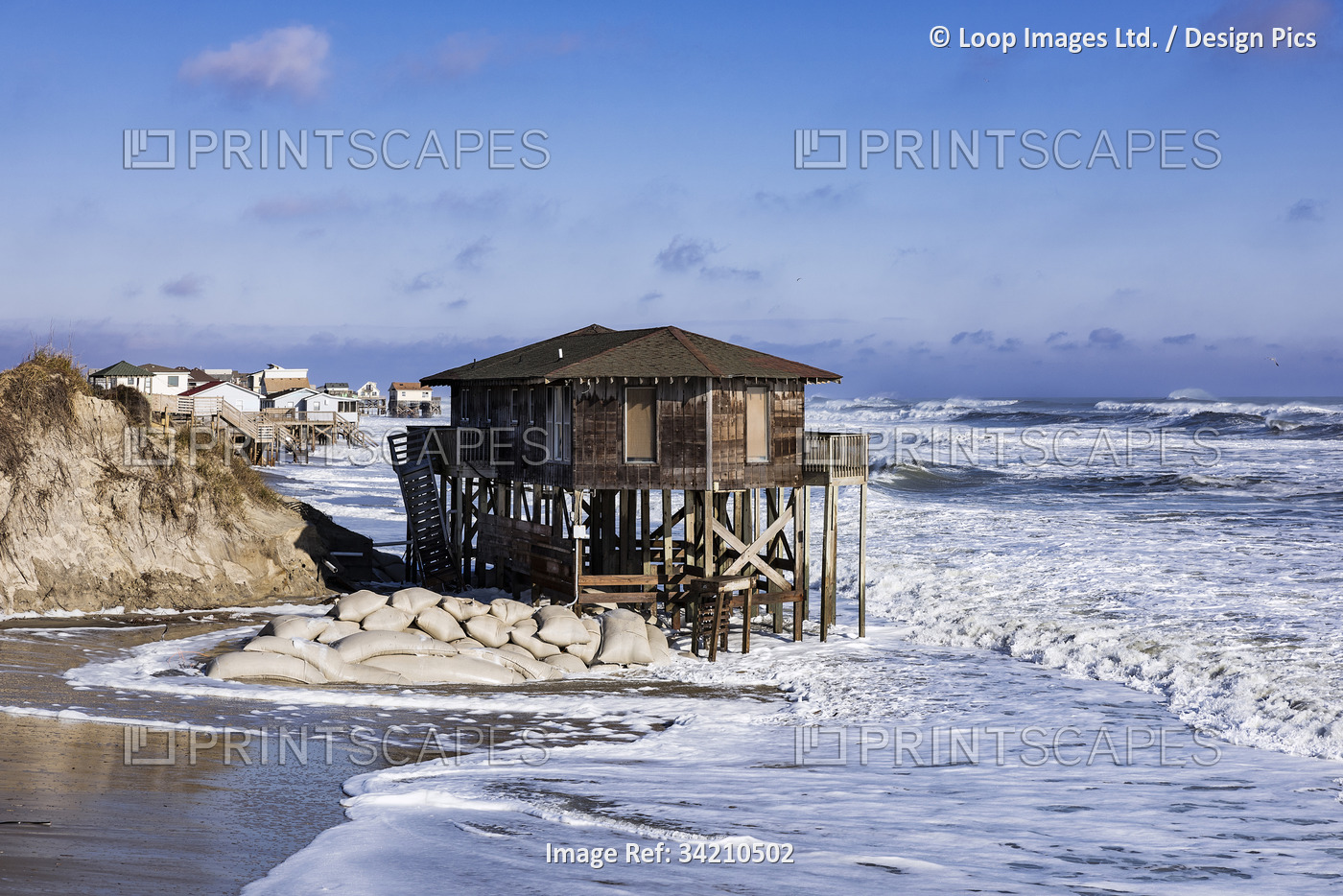 Nags Head beach house on stilts surrounded by high tide storm surf.