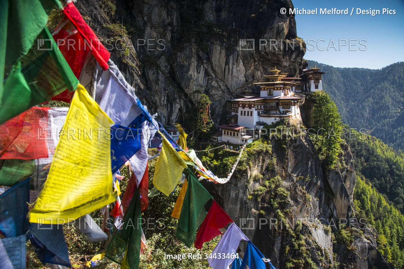 Prayer flags span the chasm before the Tiger's Nest Monastery in the Himalayas ...