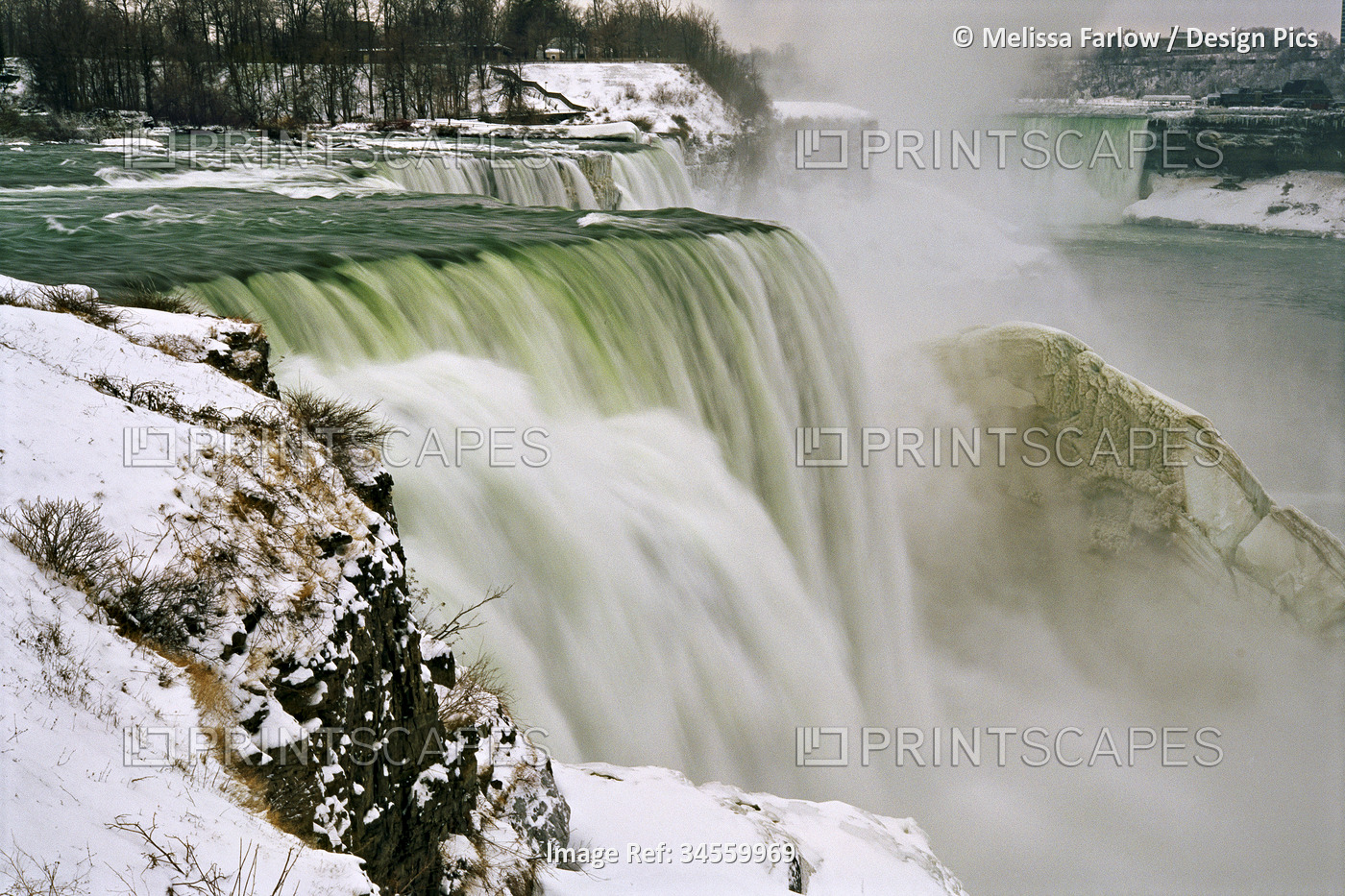 Winter view of cascading Niagara Falls where mist and spray form a crust of ice ...