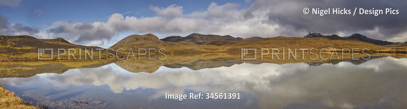 Landforms and cloud formations and their mirror reflection in a lake at ...