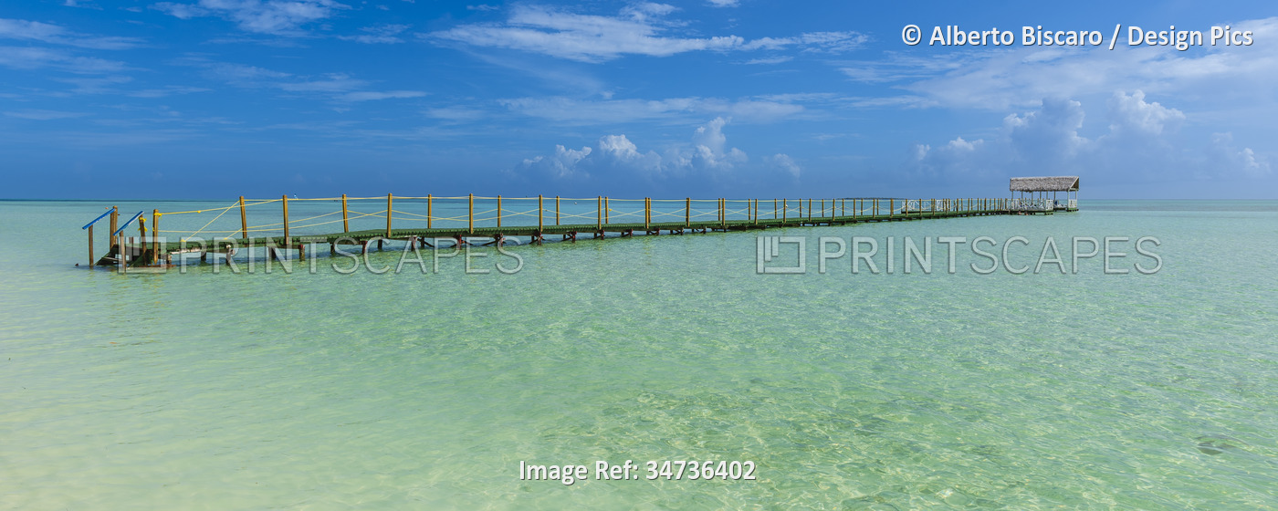 View of a jetty in the turquoise water off the beach of a resort in Cayo ...