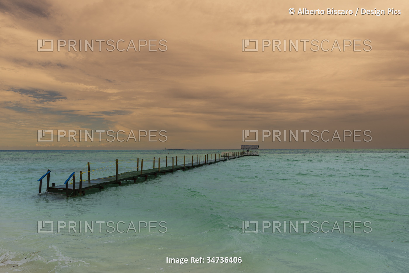 View of a jetty in the turquoise water off the beach of a resort in Cayo ...